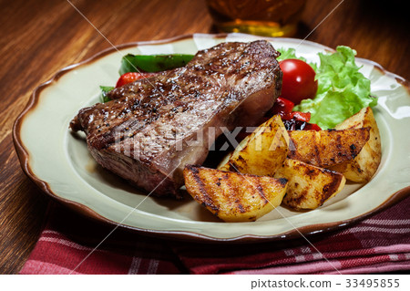 图库照片: portions of grilled beef steak with potatoes