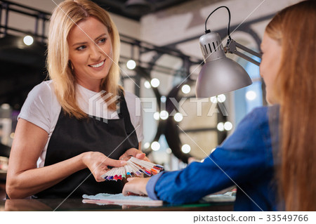 图库照片: gorgeous young manicurist demonstrating nail