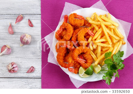 图库照片: breaded fried shrimps, limes and french fries