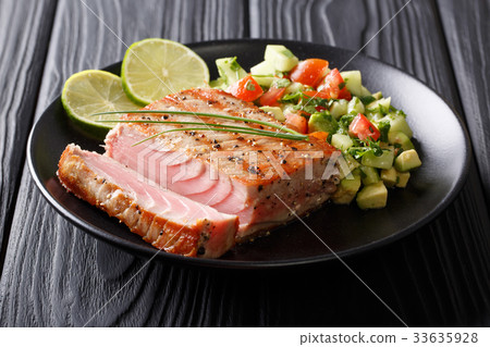 图库照片: grilled tuna steak with pepper and avocado salsa