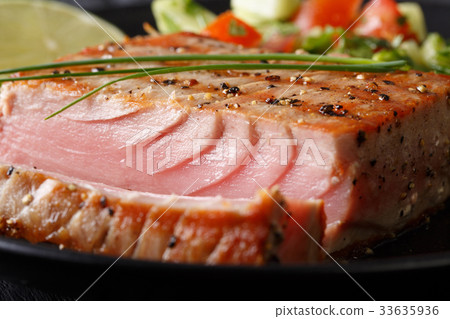 图库照片: grilled tuna steak with pepper macro. horizontal