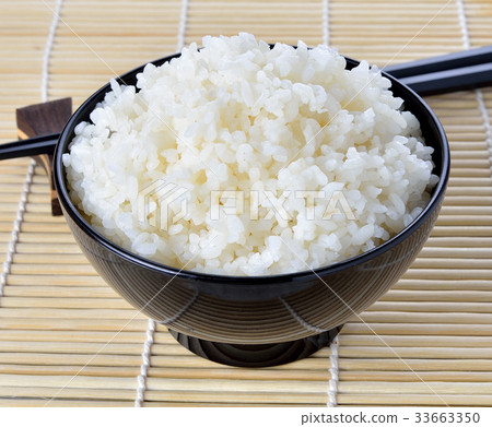 图库照片: white steamed rice in black round bowl