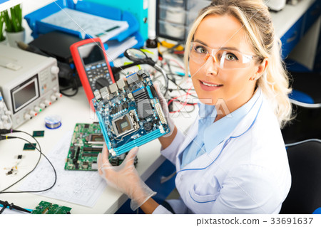 图库照片: female electronic engineer holding motherboard