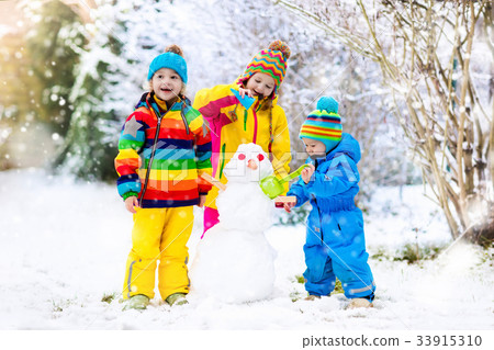 children make snowman,childrenworld系列 图库照片: kids building snowman. children in snow winter fun