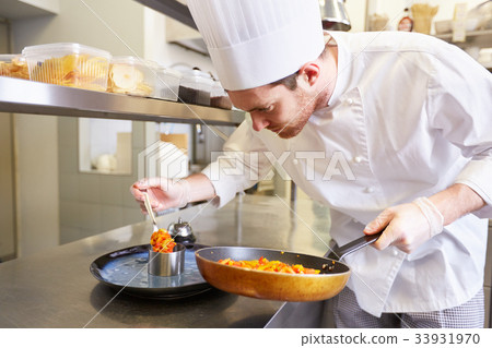 图库照片: happy male chef cooking food at restaurant kitchen