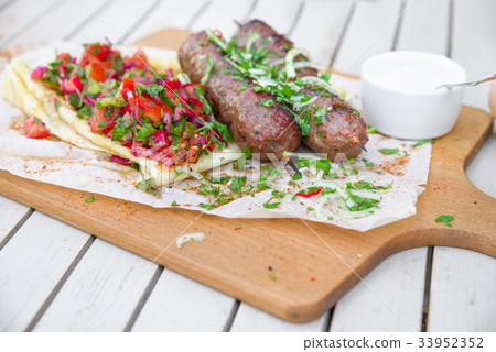 图库照片: meat kebab of minced beef or lamb with vegetables.