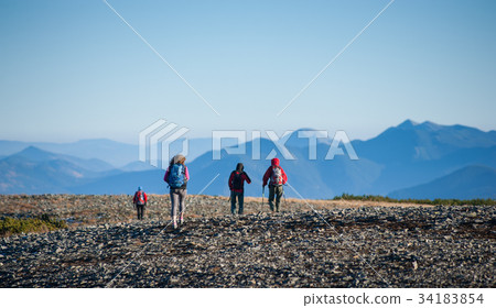 图库照片: group of four people walking on the rocky mountain