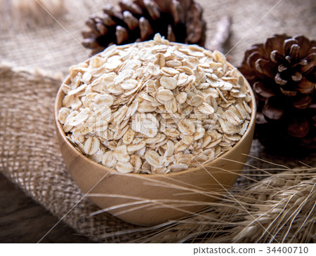 图库照片: rolled oats (oat flakes), wheat ears on wooden