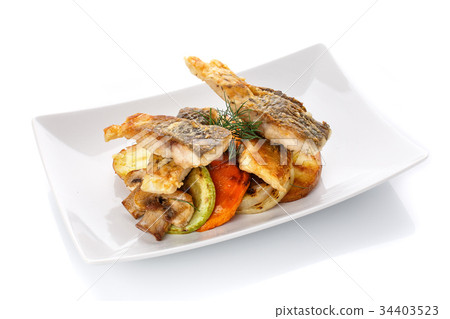 图库照片: fried fish with vegetables on a plate. isolated on