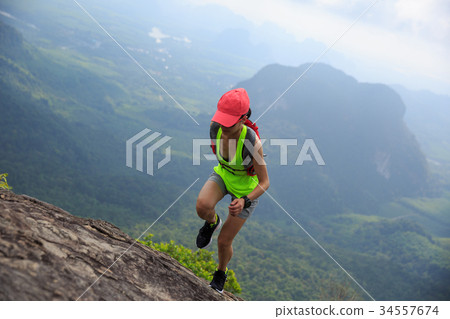 图库照片: fitness woman trail runner running at mountain top