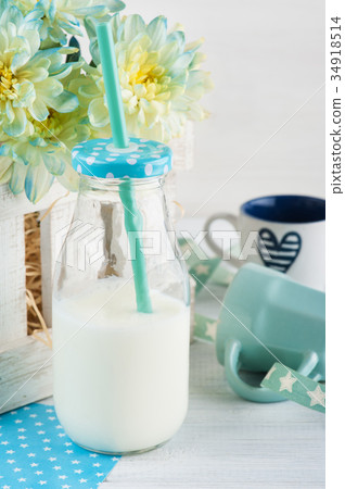 图库照片: bottle of milk with straw and blue cup