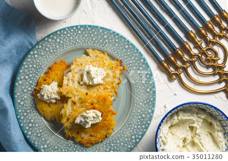 图库照片: latkes and curd cheese on a plate and on a blue