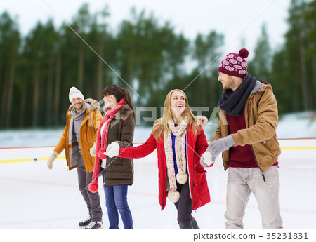 图库照片: friends holding hands on outdoor skating rink