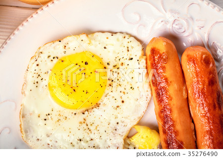 图库照片: breakfast of sunny side up eggs, fried sausages