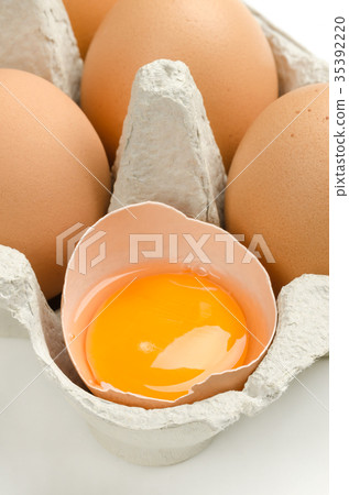 图库照片: open chicken egg in gray egg carton