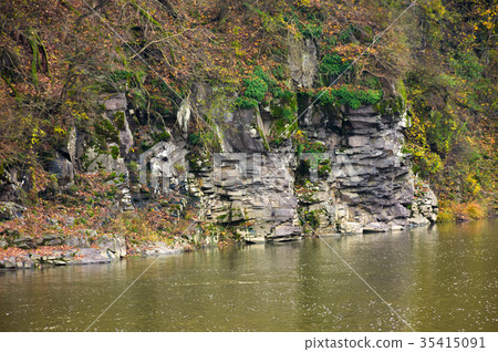 图库照片: rocky cliff over the river in forest