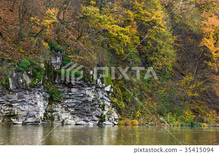 图库照片: rocky cliff over the river in forest