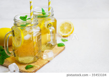 图库照片: green ice tea with lemon and mint in a glass jar