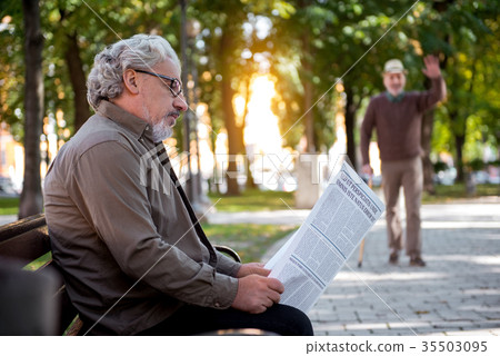 图库照片: pensive pensioner is interested in news