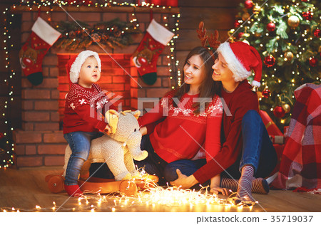 图库照片: happy family mother father and baby at christmas tree