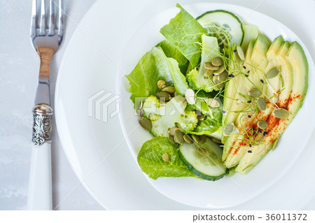 图库照片: green salad with broccoli, sprouts and avocado.