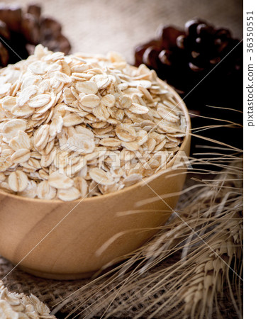 图库照片: rolled oats (oat flakes),wheat ears on wooden