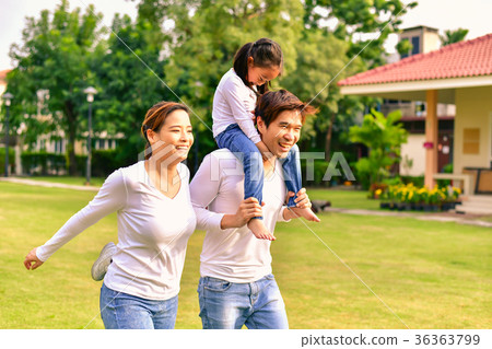 图库照片: parents and daughters go for a walk in the park.