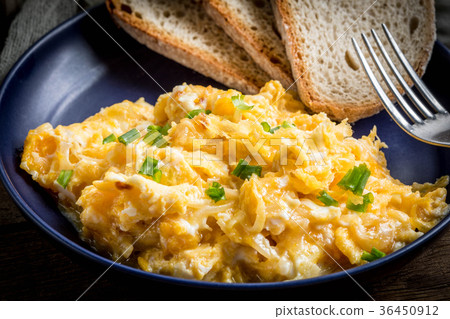 图库照片: scrambled eggs with onion and chives.