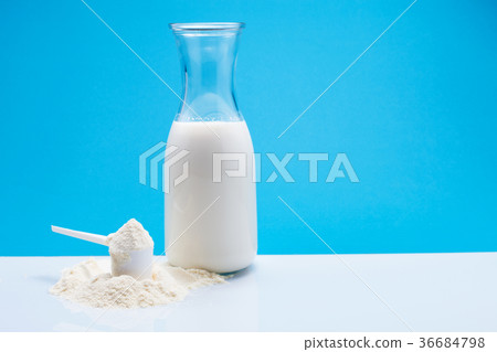 图库照片: bottle of fresh milk with powdered milk and spoon