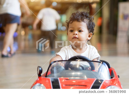 图库照片: asian baby boy driving in a red car toy 查看全部