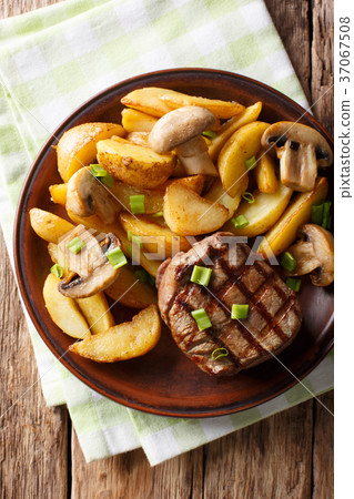 图库照片: juicy fillet mignon with fried potato wedges