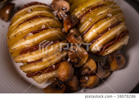 图库照片: detail of two roasted potatoes with gouda cheese