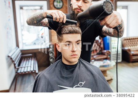 图库照片 man getting trendy haircut at barber shop.