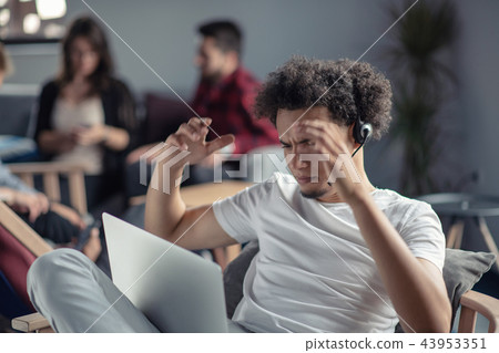 照片素材(图片): worried man with curly hair working on laptop.