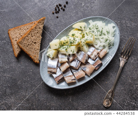 图库照片: herring fish with potatoes and onion, rye bread