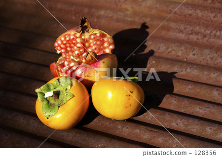 新鮮採摘的石榴和柿子放在馬口鐵盤上 128356