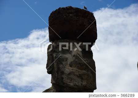 A moai statue wearing Pukao and a small bird A moai statue wearing Pukao and a small bird 366289