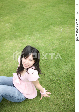 一個女人坐在草坪上 一個女人坐在草坪上 370524