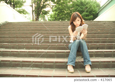 A woman reading a book on the stairs 18 417065