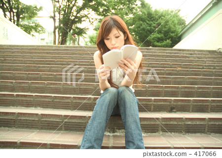 A woman reading a book on the stairs 17 417066