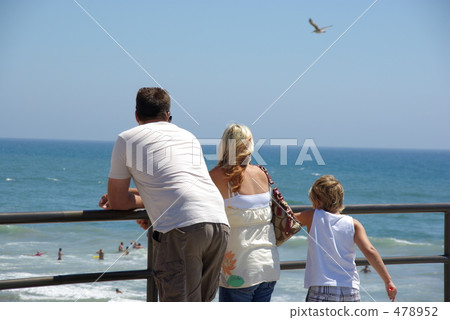 Back view of a family enjoying a holiday on an American beach Back view of a family enjoying a holiday on an American beach 478952