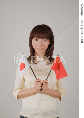 A woman with a flag of Japan and China A woman with a flag of Japan and China 499224