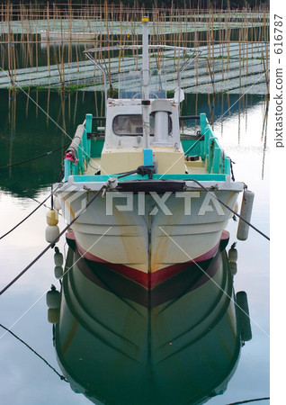 Water surface like a mirror and a fishing boat 616787