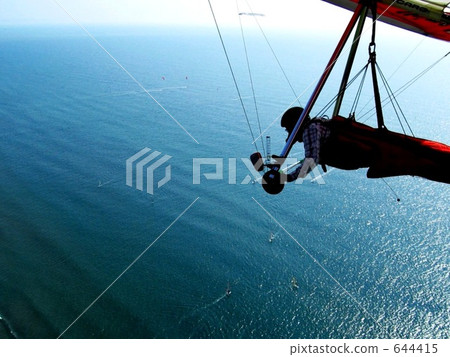 Flying over the sea with a hang glider Flying over the sea with a hang glider 644415