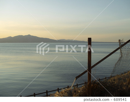 Evening scenery of the mountains, the sea and a torn fence 689541