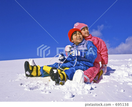 Siblings riding a sled 695138