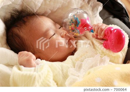 Baby sleeping with rattle in hand Baby sleeping with rattle in hand 700064