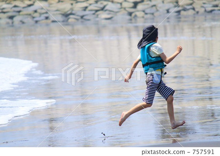 A girl in a life jacket playing with waves 757591