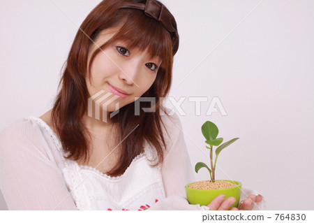 A woman holding a foliage plant 764830