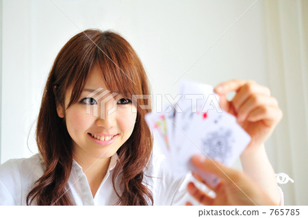 一對男女在玩紙牌遊戲;年輕女性,十幾歲的女孩。 一對男女在玩紙牌遊戲;年輕女性,十幾歲的女孩。 765785